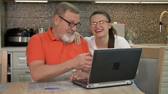 Beautiful Young Woman Is Explaining To Her Elderly Father How To Shop and Various Payments Online alt