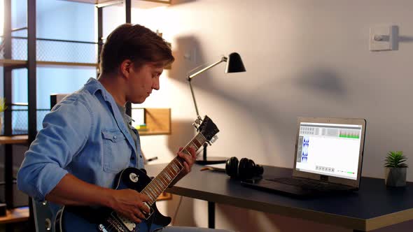 Man Playing Guitar and Recording Music at Home alt