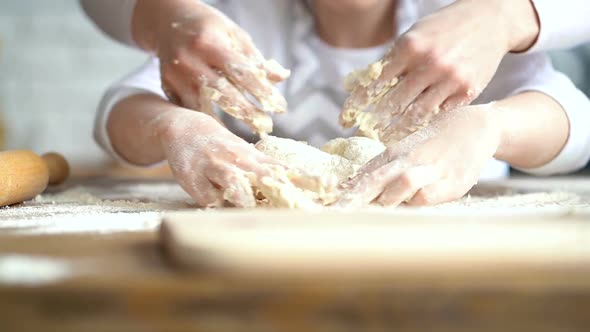 Mother and Daughter Kneading Dough on The Kitchen Table