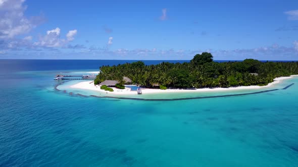 Wide angle aerial tourism shot of a white paradise beach and blue ocean background in colourful 4K alt