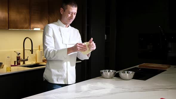 professional chef kneads the dough to form a floured pizza dough. Italian dish