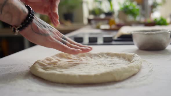 Hands Flattening Dough for Pizza alt