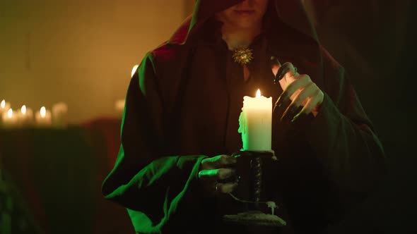 Witch Woman Holding Burning Candle Closeup alt