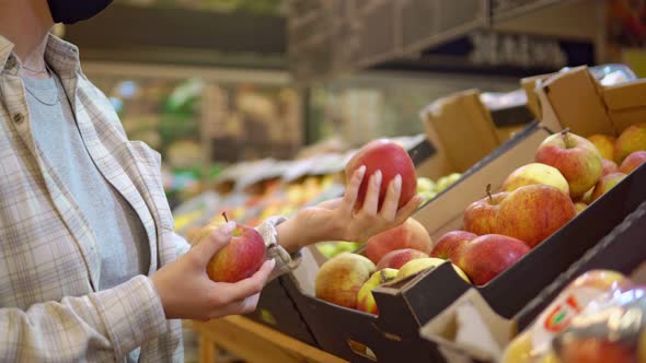 Woman in Supermarket Choosing Apples Shelves of Fruits in Markets