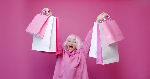 Happy Girl Enjoys After Shopping with Colorful Bags in Pink Colour Concept alt
