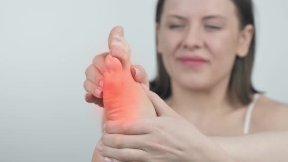 Woman Touching Foot in Pain Close Up