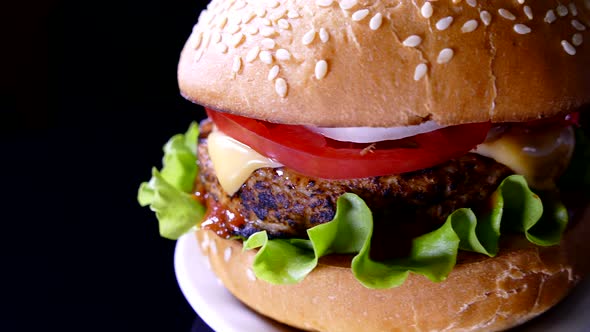 Appetizing burger on a black background. Delicious fast food.