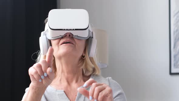 An Old Grandmother Relaxes in Virtual Reality Glasses alt