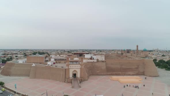 Ark of Old Bukhara City Fortress Panorama Filmed By Drone From Front Gate on a Warm Cloudy Day alt