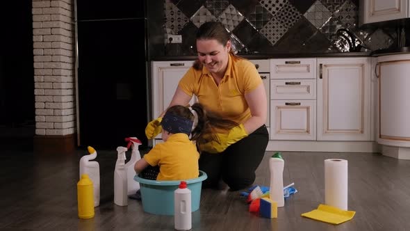 Mother and Daughter Have Fun Together Cleaning the House the Girl Sits in Basin alt