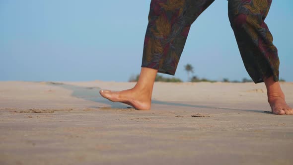 Feet of Active Senior Woman Practicing Tai Chi Gymnastic on Sandy Beach
