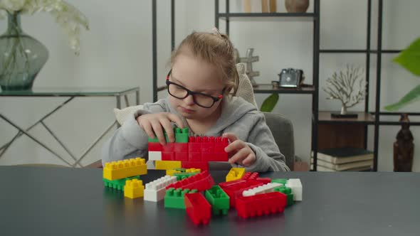 Little Girl with Down Syndrome Playing with Toy Blocks alt
