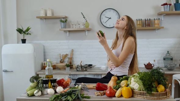 Girl Recommending Eating Raw Vegetable Food. Showing Avocado in Hands. Weight Loss and Diet Concept alt