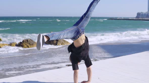Young Strong Man Showing Impressive Strength Doing a Handstand alt