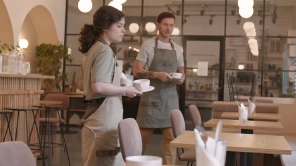 Two Waiters Setting Tables in Cafe alt