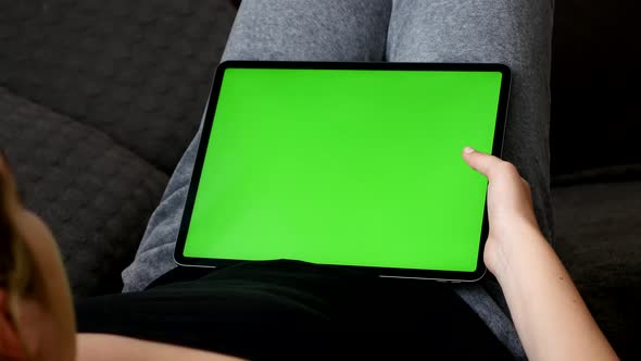 Big tablet green screen display in female lap 4K footage