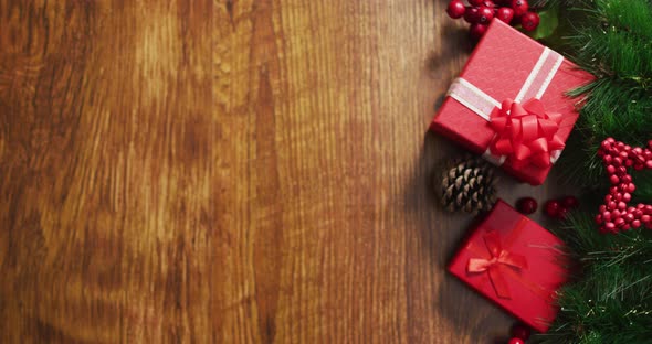 Video of christmas decorations with presents and copy space on wooden background alt