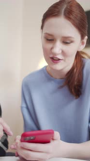 A Woman Shows Her Elderly Father Photos on Her Phone alt
