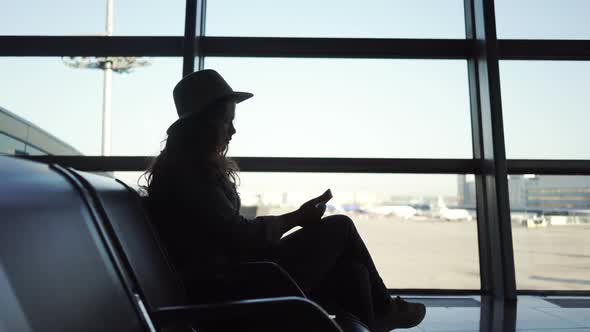 Young Woman Using Smartphone in Airport