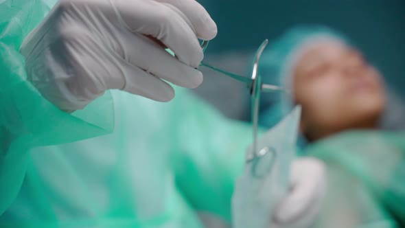 Closeup Shot of Nurse Taking the Surgical Scissors Out of the Sterile Bag alt
