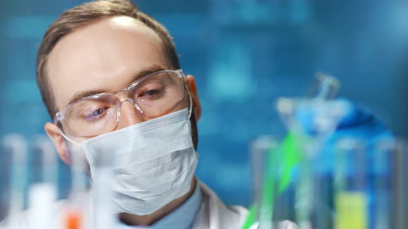 Closeup Portrait of Male Chemic Doctor Wearing Protective Mask Working on Vaccine From Virus alt