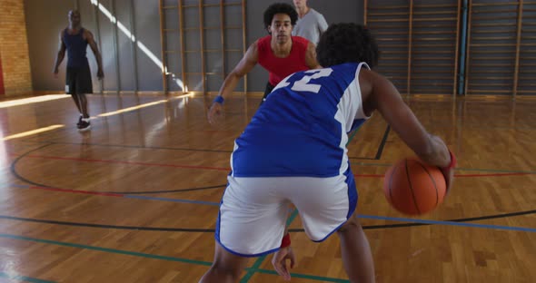 Diverse male basketball team and coach playing match alt