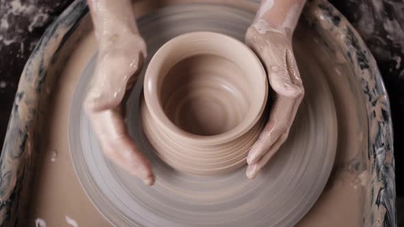 Man Potter Working on Potters Wheel Making Ceramic Pot From Clay in Pottery Workshop alt