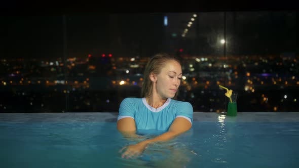 Sexy Lady Leaning on the Edge of a Rooftop Infinity Pool a Beautiful Young Woman Enjoys Cool Water alt