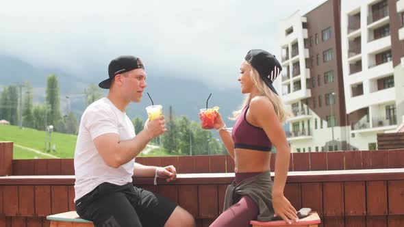 Sportive Couple Sitting in a Cafe Enjoying Fresh Drinks After Intensive Workout alt