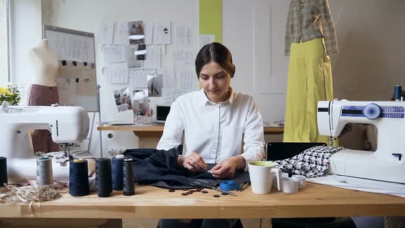 Young Female Tailor Sewing Piece of Cloth in the Sew Studio alt