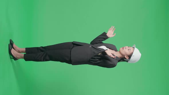 Full Body Of Side View Of Smiling Asian Female Engineer Talking In The Green Screen Studio alt