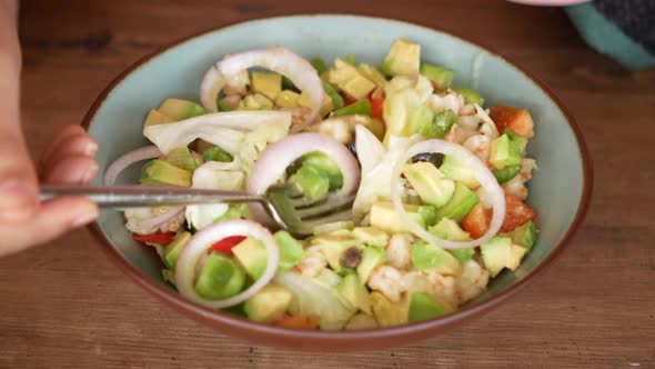 Young Women Eating Avocado Salad alt