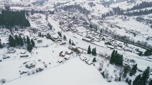 Flight Over the Town with the Railway Station in the Valley in Winter