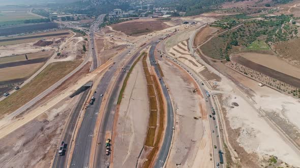 Aerial footage of large highway construction project with tunnels and bridges alt