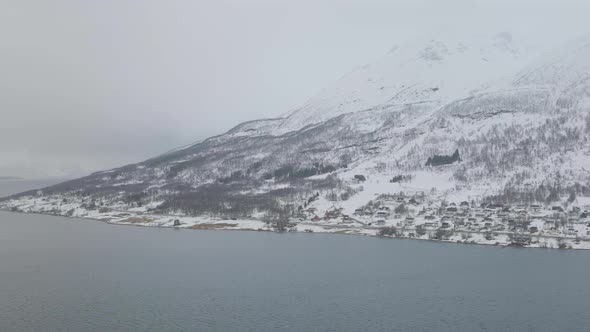 Kåfjord town and harbour by the foot of the mountain in Olderdalen, Norway. Overcast winter weather. alt
