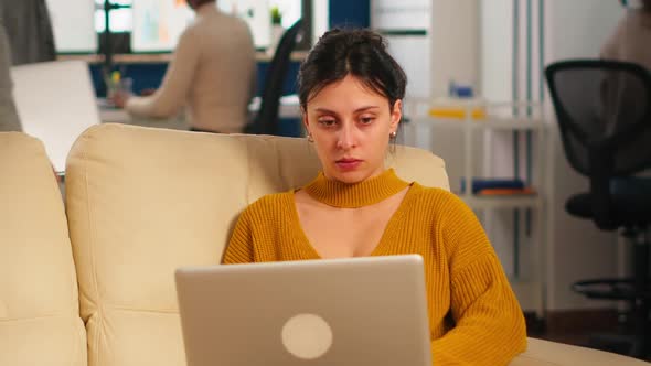Businesswoman Sitting on Couch Holding Laptop Smiling at Camera alt