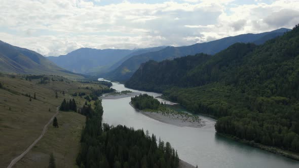 River Katun between mountains of Ak-Kem valley under cloud and blue sky in Altai