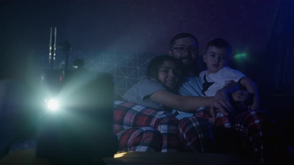 Father with Kids Watching Old Movie on Retro Projector