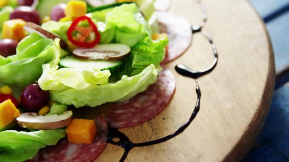 Salad decorated on wooden plate alt