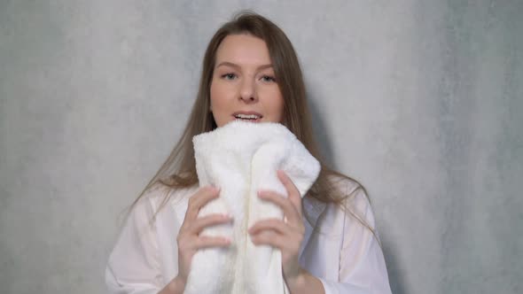 A Young Housewife Woman Takes a Stack of Fresh Washed Clean Linen in Her Hands alt