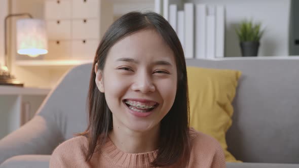 handle shot of beautiful Asian women in casual clothes and smiley with sitting on sofa. alt