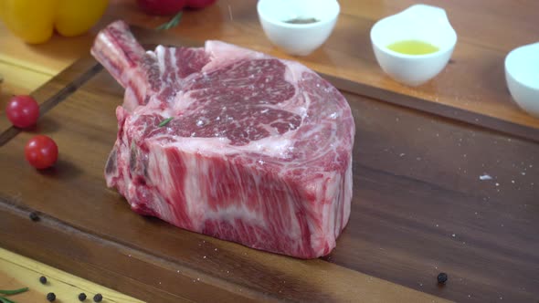 Chef cook season fresh chunk of deli piece of beef with sea salt and grounded spicy peppers. alt