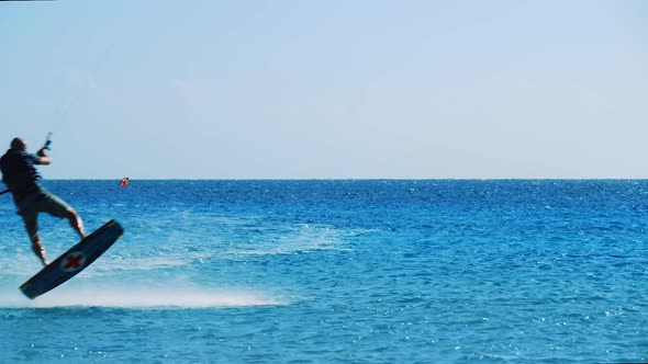 Kite surfer landing a small jump on the beautiful calm blue ocean in Bonaire, Caribbean alt