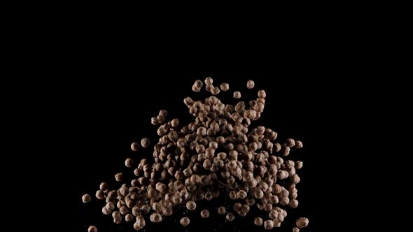 Chocolate Corn Cereal Balls Exploding in Slow Motion, Isolated Black Background