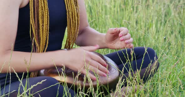 Close Up of Woman Meditating and Playing on Hang Drum alt