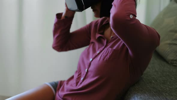 Woman using virtual reality headset in living room  alt