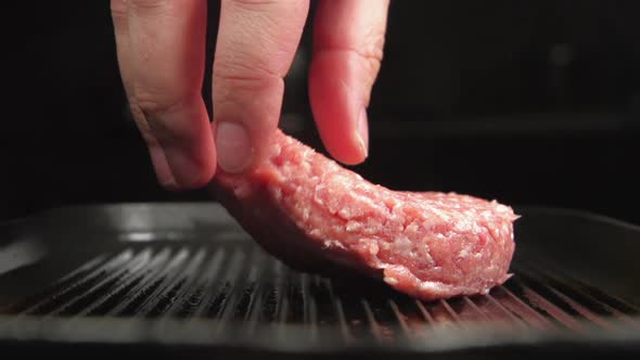 Human Hand Puts A Fresh Beefsteak On A Grill