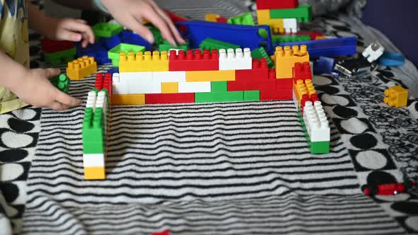 Happy Child Playing in the Colored Blocks on a Striped Sofa alt