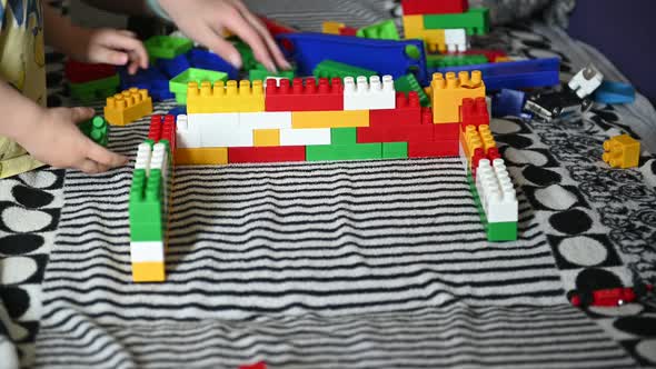 Happy Child Playing in the Colored Blocks on a Striped Sofa