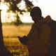 Man Hiker Backpacker Traveler Camper with Her Phone Looks at a Map or Route Under Sun Light - VideoHive Item for Sale